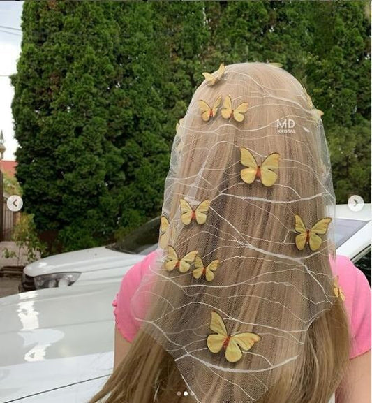 Back view of a light mesh veil with yellow butterfly decorations draped over long loose hair